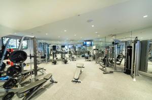 een fitnessruimte met veel apparatuur en een spiegel bij Lovely Texas Medical Center 1 Bedroom Luxury Suite in Houston