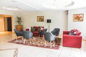 ein Wohnzimmer mit einem roten Sofa und Stühlen in der Unterkunft Perła Świeradowa in Świeradów-Zdrój