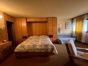 a bedroom with a bed and a chair in it at Appartamento I Dadi Cervinia in Breuil-Cervinia
