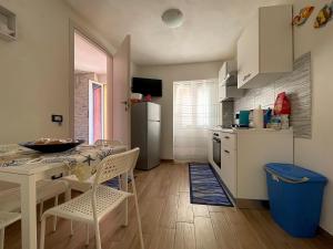uma cozinha com uma mesa e cadeiras e um frigorífico em Domus Caricatore em Sciacca