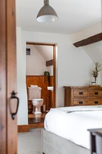 a bedroom with a white bed and a toilet at Rustic 5 Bed Farm House in Derbyshire, sleeps 9 