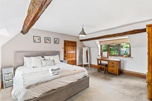 a bedroom with a bed and a desk and a window at Rustic 5 Bed Farm House in Derbyshire, sleeps 9 in Snarestone
