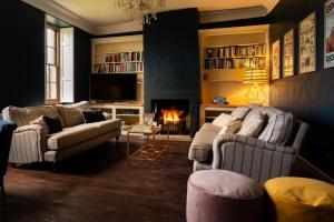 a living room with two couches and a fireplace at Upside house Beautiful 5 bedroom house sleeps 13 with hottub, games room and garden near Bath in Shepton Mallet