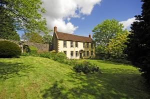 a large white house on a green field at Upside house Beautiful 5 bedroom house sleeps 13 with hottub, games room and garden near Bath in Shepton Mallet