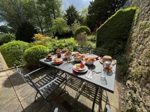 a table with plates of food on it in a garden at Upside house Beautiful 5 bedroom house sleeps 13 with hottub, games room and garden near Bath in Shepton Mallet