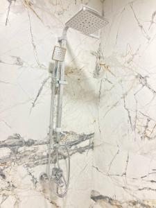 een douche in een badkamer met marmeren muren bij Апарт Отель in Poti