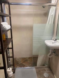 een badkamer met een douche en een wastafel bij piso 2, en Piedrasblancas a 5 min, 1,5 kilometros de la playa de salinas in Piedras Blancas
