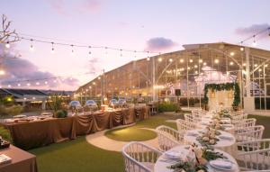 a wedding reception with white tables and chairs and lights at Infinity8 Bali in Jimbaran