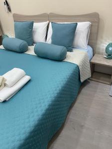 a blue bed with pillows on it in a room at Si Viaggiare Apartments in Partinico