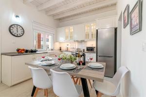 a kitchen with a table with chairs and a refrigerator at S&K Luxury Μaisonette in Potamós