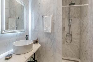 a white bathroom with a sink and a shower at S&K Luxury Μaisonette in Potamós