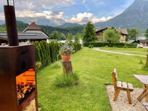 a backyard with an outdoor grill with a table and a chair at Landhaus Hallstättersee in Bad Goisern