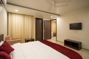 um quarto de hotel com uma cama e uma televisão em Sheerha Royal Residency em Jaipur