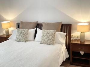 a bedroom with a white bed with two lamps at La Caseta Del Cremallera in Ribes de Freser