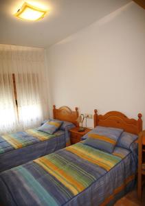 a bedroom with two beds and a lamp in it at Hostal Cuatro Esquinas in Ejea de los Caballeros