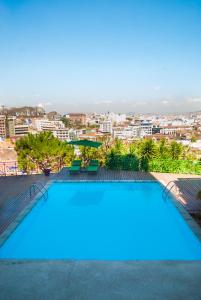 a large swimming pool with a city in the background at Hôtel & Spa Palissandre in Antananarivo