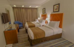 سرير أو أسرّة في غرفة في Al Massa Grand Hotel