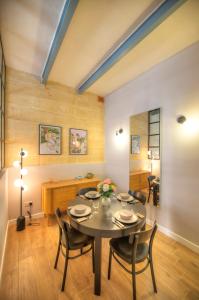 una sala da pranzo con tavolo e sedie di Beautifully furnished flat in the city center JBAL1-1 a La Valletta