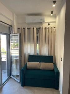 Michailidis Rooms في كينيتا: أريكة زرقاء في غرفة بها نافذة