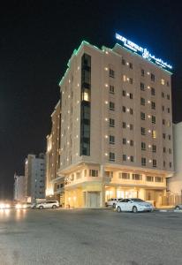 un hôtel la nuit avec des voitures garées devant lui dans l'établissement فخامة الضيافة - Dyafa Luxury, à Khobar