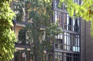 un grand bâtiment avec un arbre devant lui dans l'établissement Actual Home Gran Via, à Barcelone