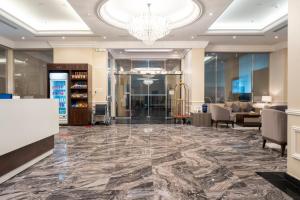 - un hall avec un sol en marbre et un lustre dans l'établissement فخامة الضيافة - Dyafa Luxury, à Khobar