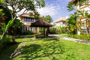 a garden with a gazebo in front of a house at Desamuda Village in Seminyak