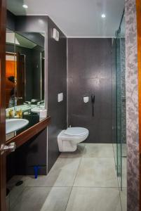 a bathroom with a toilet and two sinks and a shower at Palissandre ANTANANARIVO in Antananarivo