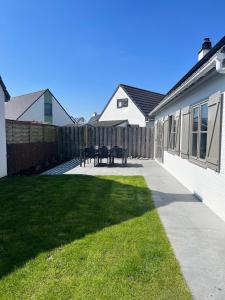 a backyard with a fence and a table and chairs at Nieuwendamme 88 in Nieuwpoort