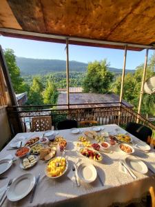 a table with plates of food on it with a view at Guesthouse Mabu - 4 Newly Built Rooms in the Heart of Mestia in Mestia