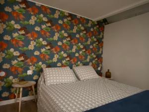 1 dormitorio con 1 cama y papel pintado con motivos florales en Sunset Bricqueville sur mer, en Bricqueville-sur-Mer