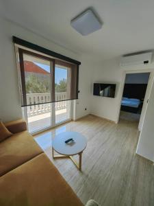 ein Wohnzimmer mit einem Sofa und einem Tisch in der Unterkunft Zvonćica Deluxe in Vodice