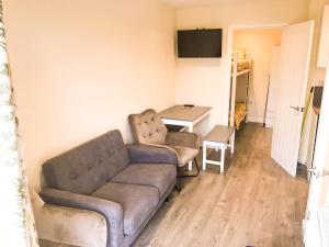 a living room with a couch and a table at Rabbits Warren A 2 Bed Holiday Let in The FOD in Blakeney