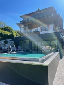 a house with a swimming pool in front of it at Landhaus Gappmaier in Saalbach Hinterglemm