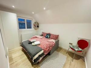 um quarto com uma cama e uma cadeira vermelha em Rooms in a beautiful house with free on St parking em Hove