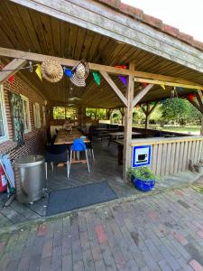 a patio with a wooden pergola with a table at Familiehuis Boysen Bed&Breakfast in Ribe