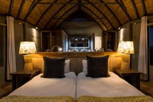 a bedroom with two beds and two lamps at Mowani Mountain Camp in Khorixas