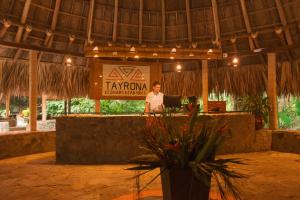a woman standing in front of a podium in a resort at Ecohabs Tequendama Playa Cañaveral Parque Tayrona in El Zaino