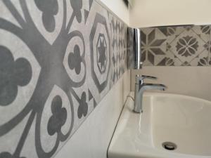 a bathroom with a sink and a tile wall at Villa Caravaggio Comfort e Relax in Rocca San Giovanni