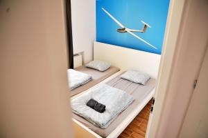 een kamer met twee bedden en een klok aan de muur bij Apartamenty Lotnisko Leszno in Leszno