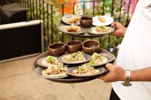 una persona che tiene un piatto di cibo su un vassoio di Casa Pepe a Puebla