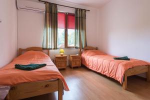 two twin beds in a room with a window at Villa ADORA in Balchik