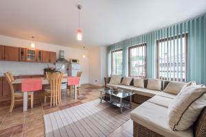 Una sala de estar y una cocina con un sofá y una mesa. en Villa ADORA, en Balchik