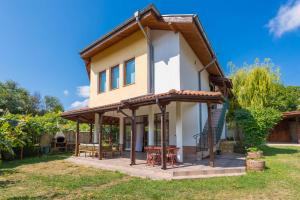 una pequeña casa con porche y valla en Villa ADORA, en Balchik