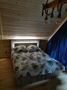um quarto com uma cama com uma cortina azul em Dziki zakątek Piskornia dom z balią jacuzzi em Piskornia