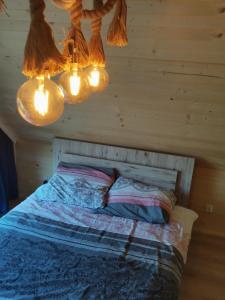 a bedroom with a bed with lights above it at Dziki zakątek Piskornia dom z balią jacuzzi in Piskornia