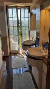 a bathroom with two sinks and a large window at "LA TAVERNA" B&B in Airuno +106 photos