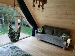 uma sala de estar com um sofá e uma janela em Dziki zakątek Piskornia dom z balią jacuzzi em Piskornia