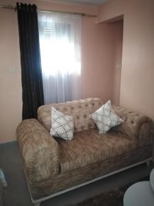 a couch with two pillows on it in a room at Executive Studio in Nakuru