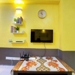 Habitación con TV en una pared amarilla en Comfy Stay @Permai Puteri Ampang nearby KLCC, IJN, en Ampang